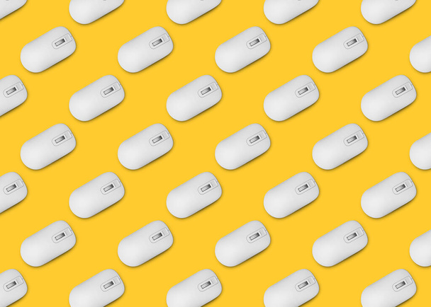 Many white computer mouses on yellow background, flat lay. Seamless pattern design - Foto, immagini