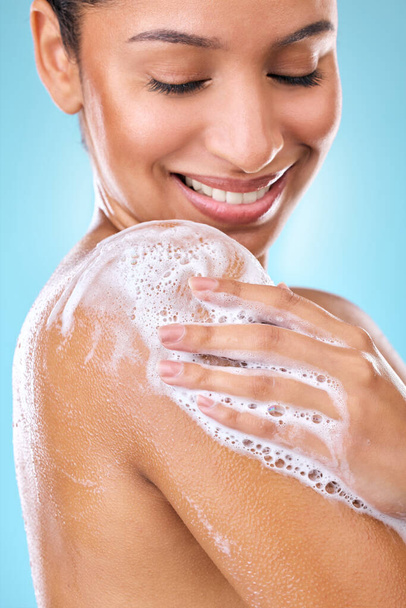 Cropped shot of a woman using a body wash on her skin. - 写真・画像