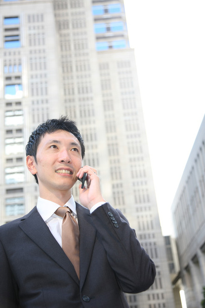 Japanese businessman talks with a mobile phon - Zdjęcie, obraz