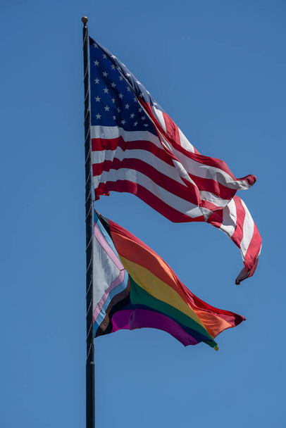 American and Rainbow Flag flying together during Pride Month - Fotoğraf, Görsel