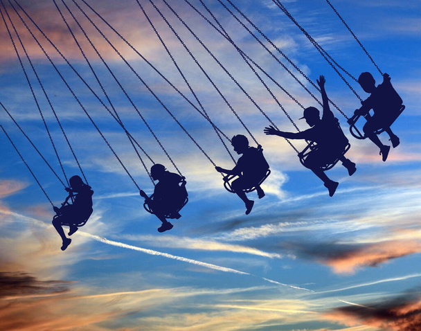 In dieser 3-D-Illustration sieht man junge Leute auf einer Schaukelstuhlfahrt mit einem schönen Himmel im Hintergrund. - Foto, Bild