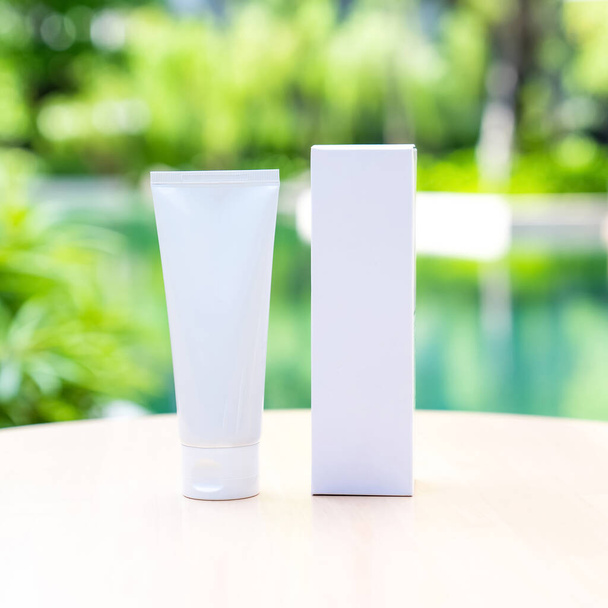 White long tubes have a front and back view surrounded by left outside on a sunny day with blur nature green background. Suitable for product samples or demo images for advertisement. Clipping Path - Foto, Imagen
