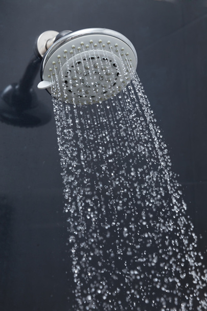 Douchekop in badkamer met waterdruppels stromend - Foto, afbeelding