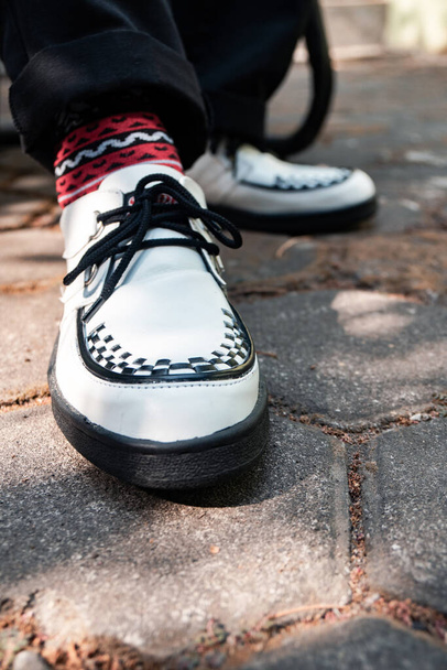 These white creepers with black-and-white webbing are made of genuine leather with black soles, these elegant and luxurious sneakers are made by a home craftsman - Foto, imagen