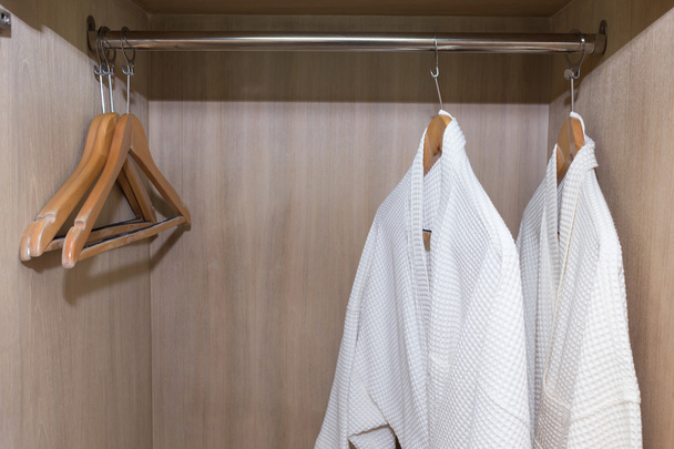 białe szlafroki wisi w szafie drewniane - Zdjęcie, obraz
