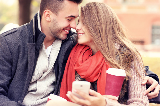 Romantický pár na lavičce s smartphone v parku - Fotografie, Obrázek