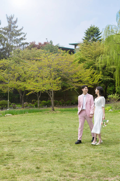 Beautiful Asian couple at wedding photoshoot in the park  - Zdjęcie, obraz