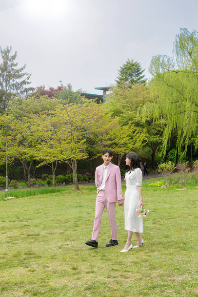 Beautiful Asian couple at wedding photoshoot in the park  - Φωτογραφία, εικόνα