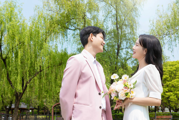 Beautiful Asian couple at wedding photoshoot in the park  - Photo, image