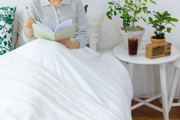 young woman reading book in bed - Φωτογραφία, εικόνα