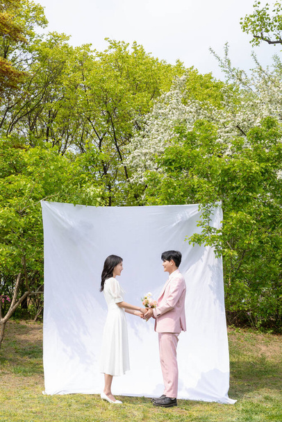 Beautiful Asian couple at wedding photoshoot in the park  - 写真・画像