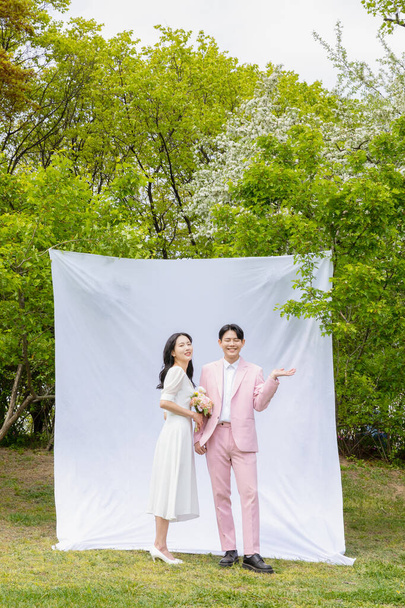 Beautiful Asian couple at wedding photoshoot in the park  - 写真・画像