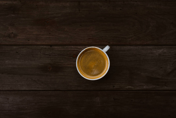 Tasse à café vue du dessus sur table en bois avec une lumière douce et ton foncé - Photo, image