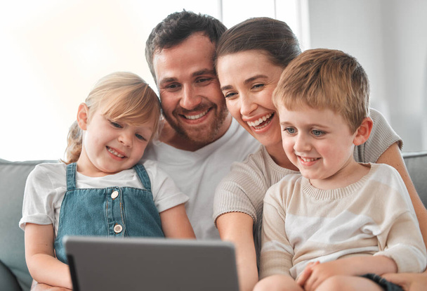 Съемка молодой семьи с помощью цифрового планшета дома. - Фото, изображение