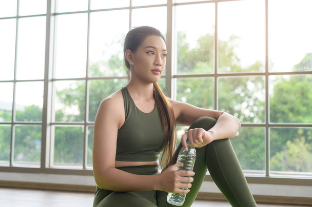 Young fitness woman in sportswear drinking water after exercising at home, Healthy and Lifestyles. - Foto, immagini