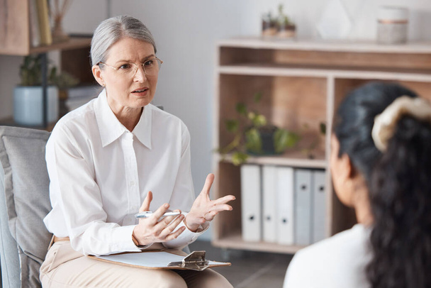 Shot of a mature psychologist sitting with her patient and asking questions during a consultation. - Foto, immagini