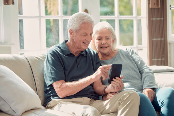 Обрезанный снимок любящей пожилой пары, сидящей в своей гостиной дома. - Фото, изображение