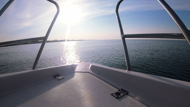海の風景、モーターボートのプロウからの太陽の反射と海の波のビュー。ボートは晴れた夏の日に波に乗ってジャンプします。海の地平線で高速ヨットモーターボートセーリング。極端なスポーツエンターテイメントの背景 - 写真・画像