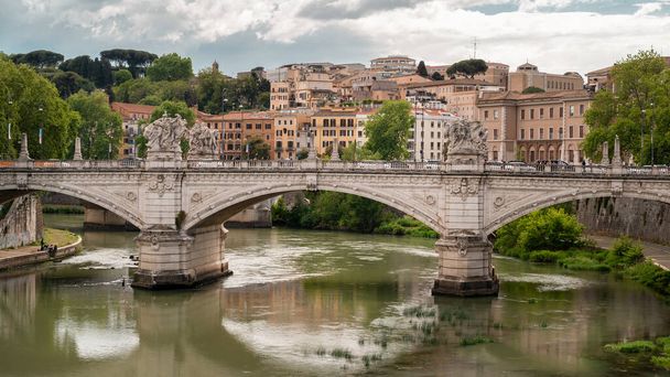 ROME, ITALY - JUNE, 2022: View of the Tiber River in the center of the city. Ancient bridge and buildings - Zdjęcie, obraz