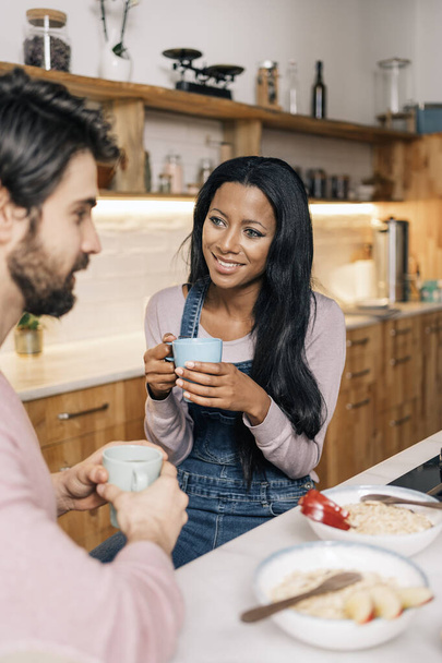Smiley black woman and her boyfriend having delicious breakfast in the kitchen at home. - Fotoğraf, Görsel