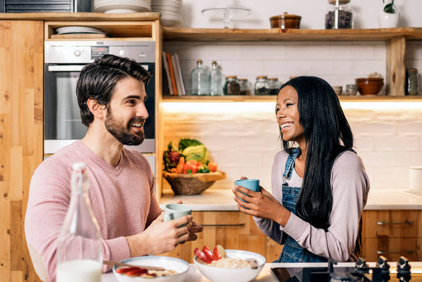 Cheerful black woman and her boyfriend having delicious breakfast in the kitchen at home. - Valokuva, kuva