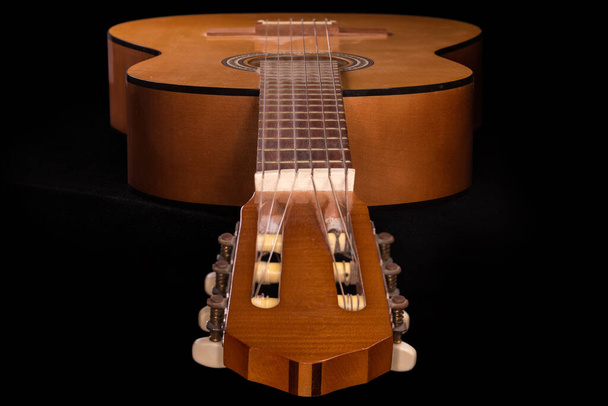 Altı telli eski geleneksel ahşap akustik gitar, seçici odaklı siyah bir arka planda başlık tarafından görünüm - Fotoğraf, Görsel