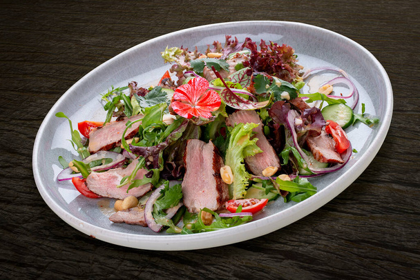 Josper-oven veal salad with sauce. On a dark background, isolated.  - Foto, Bild