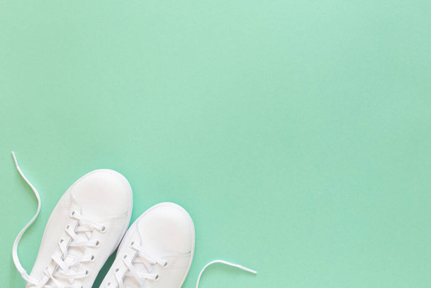 All white sneakers on mint green background. Top view,flat lay - Foto, immagini