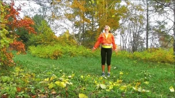 Happy woman throwing fall leaves - Footage, Video