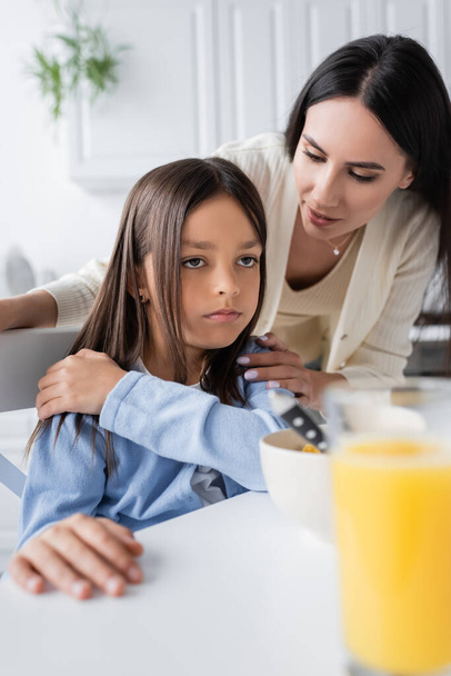 nanny talking to offended girl near breakfast on blurred foreground - Photo, Image