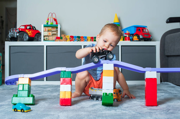 Toddler boy plays in playroom with educational toys. - 写真・画像