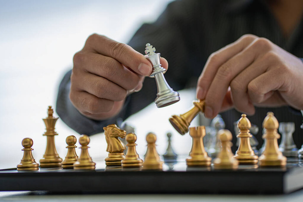 Biznesmen przesuwając pionki szachowe na szachownicy pomysły gry na pomysły i konkursy i strategie, sukces, biznes pomysłów planowania konkurencji. - Zdjęcie, obraz