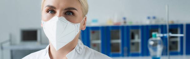 Tiedemies suojelevassa naamiossa katsomassa kameraa laboratoriossa, banneri  - Valokuva, kuva