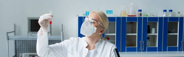 Scientist in protective mask holding test tube in laboratory, banner  - Photo, Image