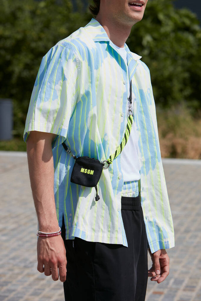MILAN, ITALY - JUNE 18, 2022: Man with flourescent green striped shirt and small MSGM bag before MSGM fashion show, Milan Fashion Week street style - Fotoğraf, Görsel