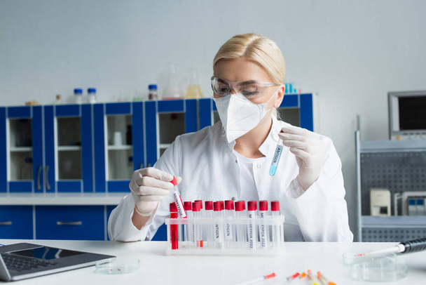 Wissenschaftler hält Reagenzgläser mit Antigen und Affenpocken-Schriftzug im Labor  - Foto, Bild