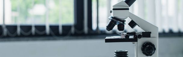 Microscope in blurred laboratory at background, banner  - Φωτογραφία, εικόνα