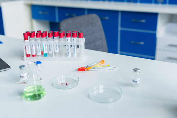 Impfstoff und Spritzen in der Nähe von Reagenzgläsern mit Affenpocken-Schriftzug im Labor  - Foto, Bild