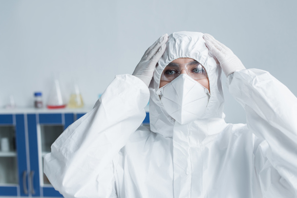 Scientist in hazmat suit and protective mask in laboratory - Photo, Image
