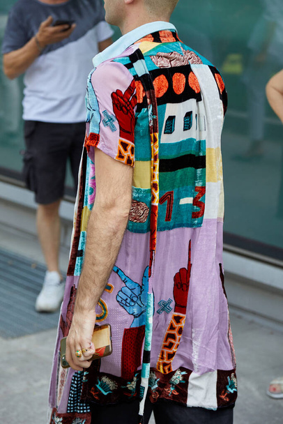 MILAN, ITALY - JUNE 18, 2022: Man with colorful patchwork jacket before Emporio Armani fashion show, Milan Fashion Week street style - Zdjęcie, obraz