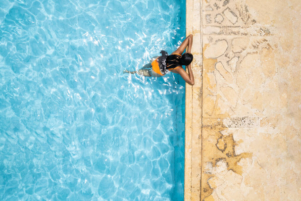 Αεροφωτογραφία της γυναίκας που αναπαύεται δίπλα στην πισίνα - Φωτογραφία, εικόνα