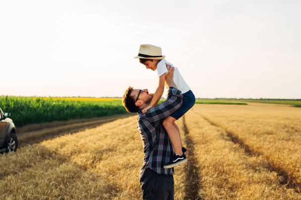 father and son enjoying time outdoor in wheat field - Foto, immagini