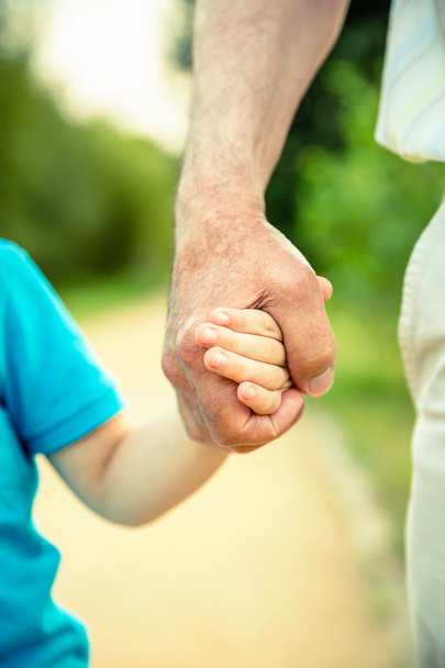 Child holding hand of senior man in the nature - Photo, Image