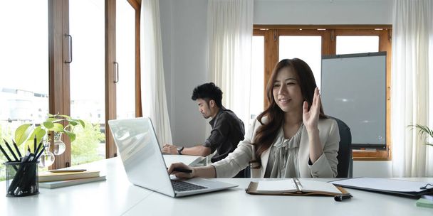 Asian female talking about sale report in video conference. Asian team using laptop and tablet online meeting in video call.Working from home remotely.. - Photo, Image