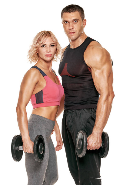 Healthy fit young sporty couple training with dumbbells - Fotografie, Obrázek