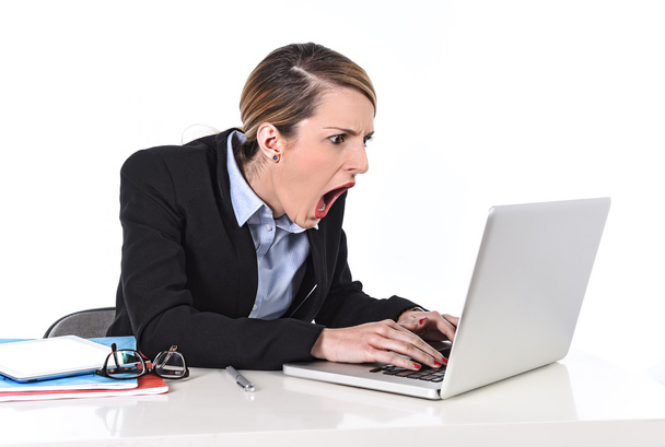 Businesswoman sitting at office desk working with laptop in stress looking upset - 写真・画像