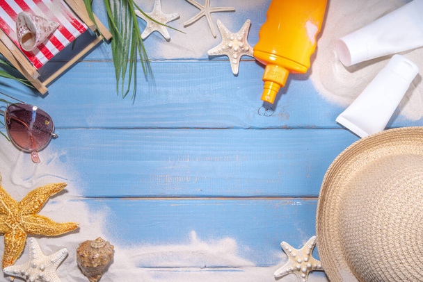 Sunscreen suncare background. Mockup background with vacation accessory, suntan lotion bottle, cosmetic cream, with seashells, straw woman's hat with sun glasses, top view copy space - Foto, imagen