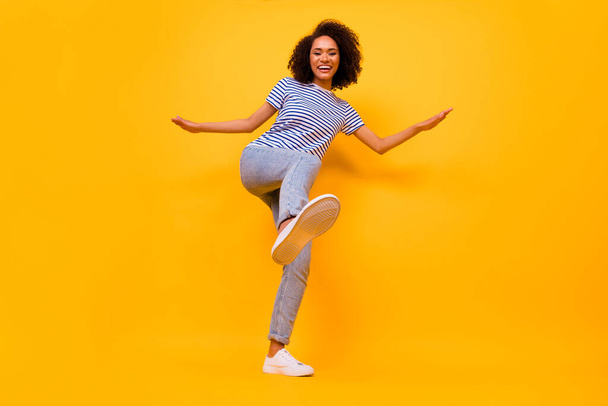 Full body portrait of excited crazy girl raise leg footwear sole dancing isolated on yellow color background. - Foto, Imagen