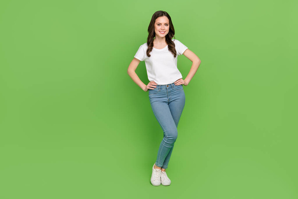 Photo of funny cute woman dressed white t-shirt arms waist smiling empty space isolated green color background. - Photo, Image