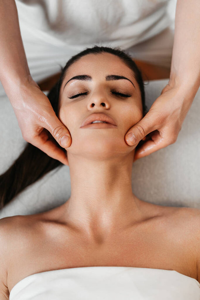 Beautiful young woman receiving professional body massage treatment with aromatherapy essential oil. - Valokuva, kuva
